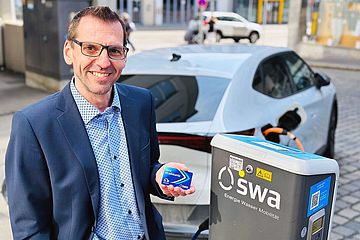 eMobilitätsexperte Markus Emmert steht neben einer swa Ladesäule