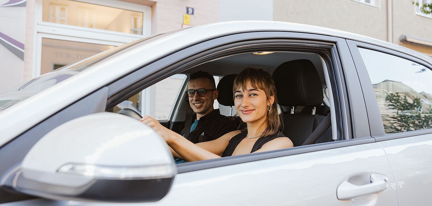 Frau und Mann sitzen in Carsharing Auto