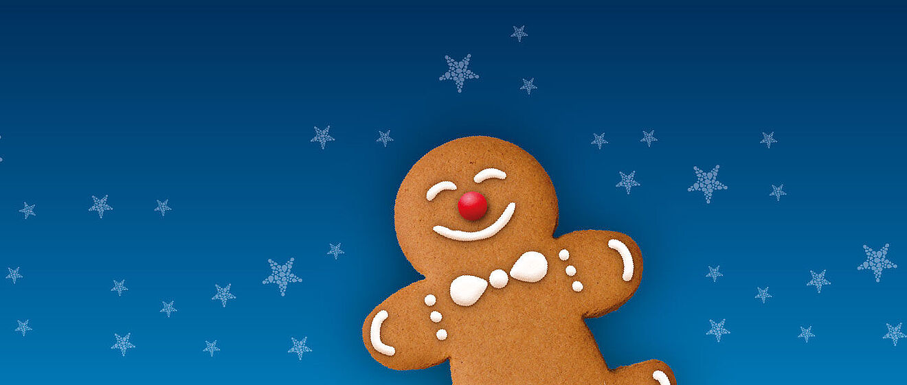 Lächender Lebkuchenmann mit Schneeflocken im Hintergrund.